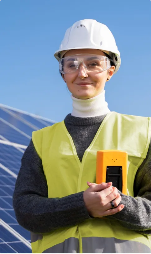 Técnica com equipamento de segurança diante de painéis solares